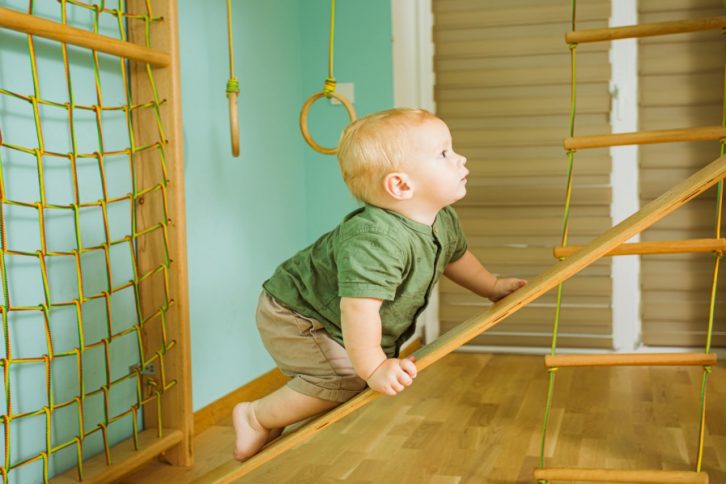 dziecko-niemowlę wspinające się po drewnianej drabince