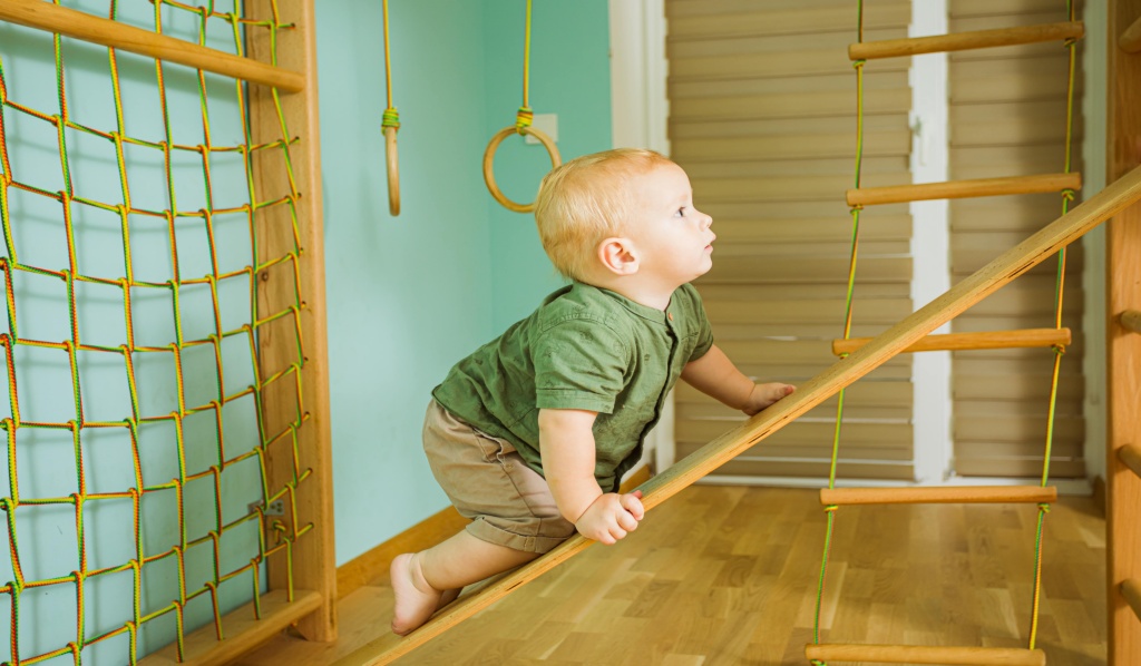 dziecko-niemowlę wspinające się po drewnianej drabince
